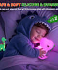 Child sleeping with Totally Adorable Dino Night Light For Kids 3 To 8 Sixteen Color Silicone Dimmable Battery Operated toy