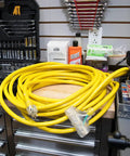 Heavy Duty Outdoor Extension Cord For Yard And Jobsite Use 15 Amp 1875 Watt Capacity Bright Yellow Jacket coiled on workbench