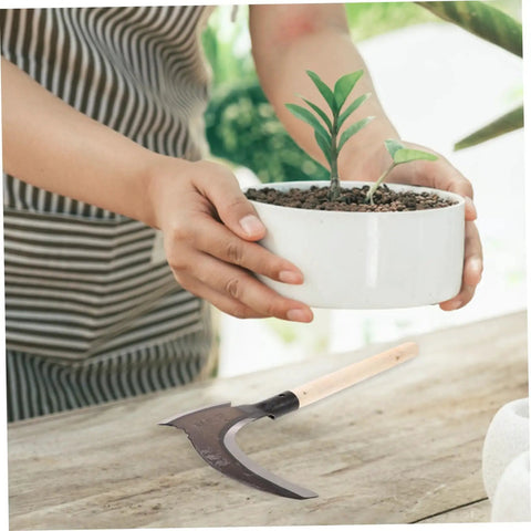 Portable Manganese Sickle for Weeding and Harvesting on wooden table next to potted plant, ergonomic and durable design