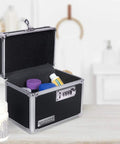 Open black Locking Medicine Box With Combination Lock for Safe Medication Storage showing pills inside, placed on a countertop.