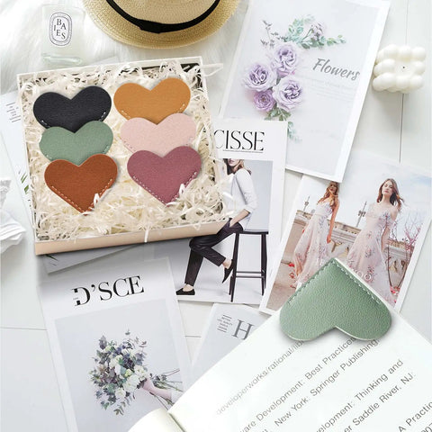 Top Tier Handmade Leather Heart Bookmarks Six Piece Set Soft Pu Leather Page Markers With Tight Stitching Designed For Serious Readers And Gifting Purposes A Straight Up Best Seller With Awesome Vibes in a gift box on magazine pages.