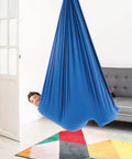 Blue 95 Percent Cotton Sensory Swing For Kids X Large Therapy Swing With Deep Pressure Support For Autism SPD And Anxiety Calming Cozy Swing With 4 Way Stretch Fabric Hardware Included, child in blue indoor swing