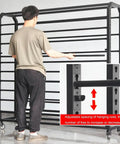 Man adjusting adjustable rods on Heavy Duty Steel Fabric Storage Rack and Vinyl Roll Holder Cart for organized vinyl rolls.