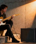 Musician playing guitar next to 50W Electric Guitar Amp Combo With 10 Inch Speaker For Home Practice And Studio Jams Powerhouse Amp