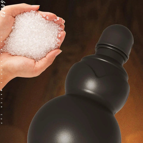 Close-up of black 900ml hydration bottle with gourd-inspired shape, made from safe PP, next to silicone granules in a hand.