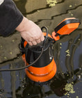 Hand adjusting 1HP Submersible Sump Pump With Automatic Float Switch, 3700GPH Clean Or Dirty Water Pump, orange, in water