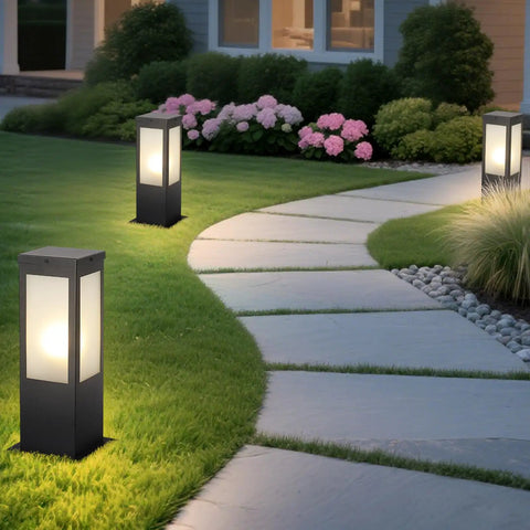Rock Solid 15.75 Inch Outdoor Bollard Path Lights With Knockout Aluminum Frame And Frosted Glass Shade illuminating garden walkway.