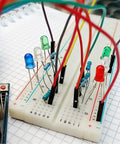 560 Piece Jumper Wire Kit For Breadboard Prototyping with assorted lengths, connected to LEDs on a breadboard for circuit building