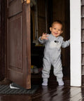 Child standing near a door secured by a 2 Piece Rubber Door Wedge With Stainless Steel Core Non Slip Door Stopper