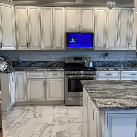 Modern kitchen with marble countertops and stainless steel appliances, featuring gold and black knurled 5-inch center bar cabinet pulls.