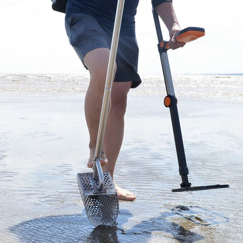 Person using Sand Scoop For Metal Detecting Stainless Steel Beach Treasure Dig Tool With Adjustable Long Handle on wet sand.