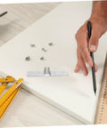 Close-up of stainless steel heavy-duty cabinet hinge mounting plate with screws on a workbench