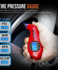 Hand holding digital tire pressure gauge from 65 Piece Compact Auto Garage Tool Kit with display showing 36.6 PSI.