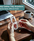 Reusable Silicone Cable Ties 20 Pack Boss Level Desktop Cord Organizers With Secure Snap Lock And Stretchy Loop Wraps To Keep Charging Cables Snug And Straight Up Tidy in use with a hand holding a wrap on a wooden desk near a laptop.