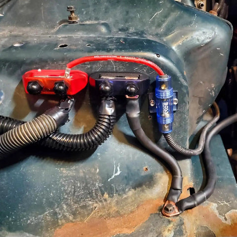 Ridiculously Strong 3/8 Power Distribution Block Bus Bar Offering Dead Serious Two Hundred Fifty Amps And Dual M10 Studs mounted on a vehicle panel.