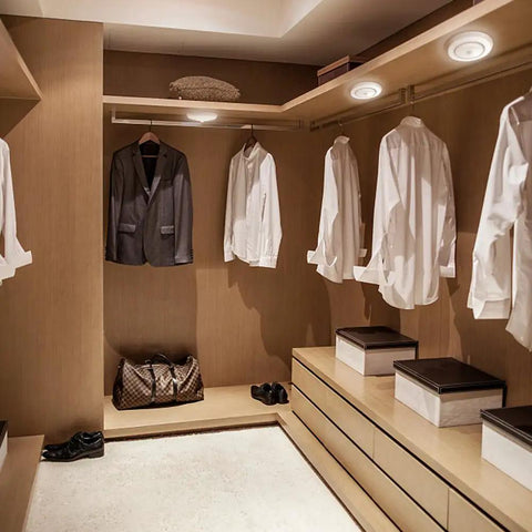 Well-lit closet with Battery Powered Closet Lights With Motion Sensor And Photocell Cordless LED Night Light Wireless Ceiling Light, shirts hanging.