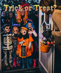Children in Halloween costumes holding lanterns, ready for trick-or-treating. Woman with candy bucket at door, text 'Trick or Treat?'