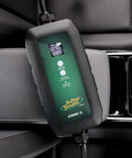 Dead Simple 16 Amp Level One Portable Ev Charger on car seat, digital screen displaying charge status and interface options.