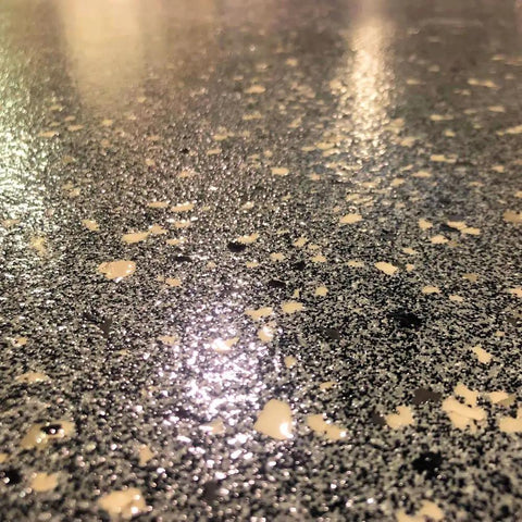Ultra Tough Polyaspartic Concrete Coating With Bulletproof Abrasion And Chemical Resistance Delivers High Gloss Sealer Protection Zero VOC Formula For Fast Cure And Epic Garage Floors 3 Quart Kit on a shiny black surface.