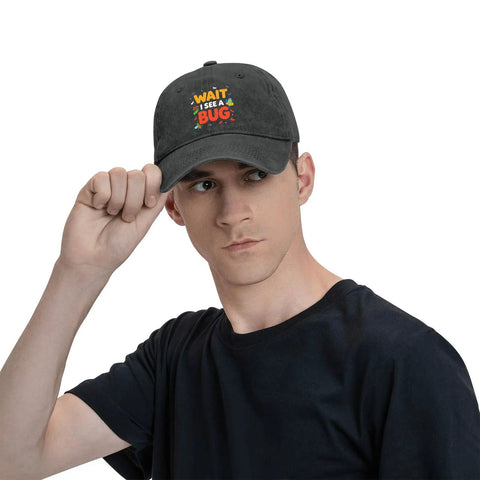 Man wearing a black cap with colorful cartoon bugs and text graphic.