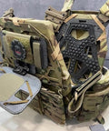 Camouflage tactical vest on display, showing multiple storage compartments and thick shoulder padding.