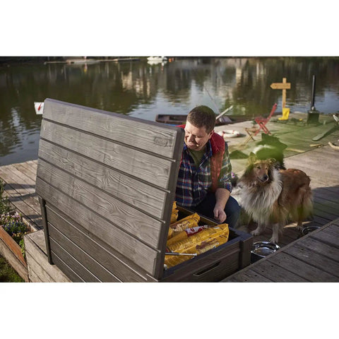 Man accessing Lockable 120 Gallon Outdoor Storage Deck Box For Patio Backyard And Garden In Brown Waterproof Plastic Bench