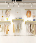 Top Shelf Wall Mounted Clothing Rack System Kit Crafted from Rock Solid Wrought Iron Pipes and Rugged Pine Boards for Boutique or Main Street Closets That Can Take Some Serious Wear and Tear, displaying outfits on a stylish setup.