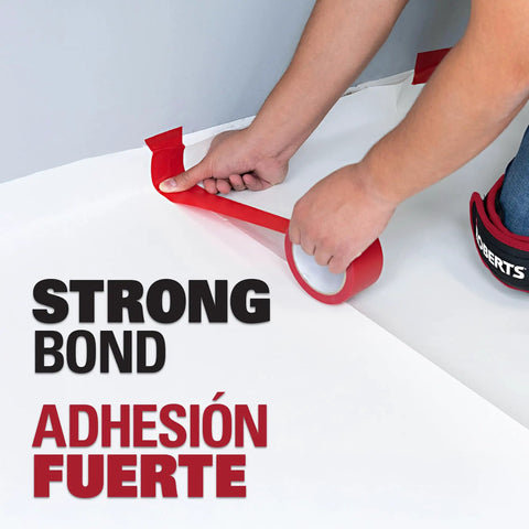 Person applying Underlayment Seam Tape 100 Feet Red For Floating Floors PVC Based Moisture Resistant Easy Tear Seams Bonding.