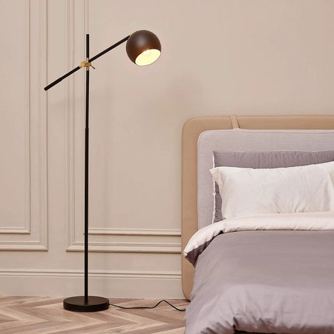 60-Inch Floor Lamp With Matte Black Finish, Brass Pivot, Metal Shade in bedroom setting.