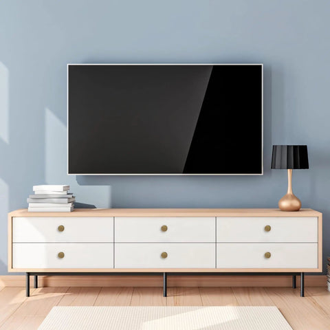 Modern living room with six-drawer console, featuring Antique Brass Cabinet Knobs Set, 6 Pack, on white drawers below TV.
