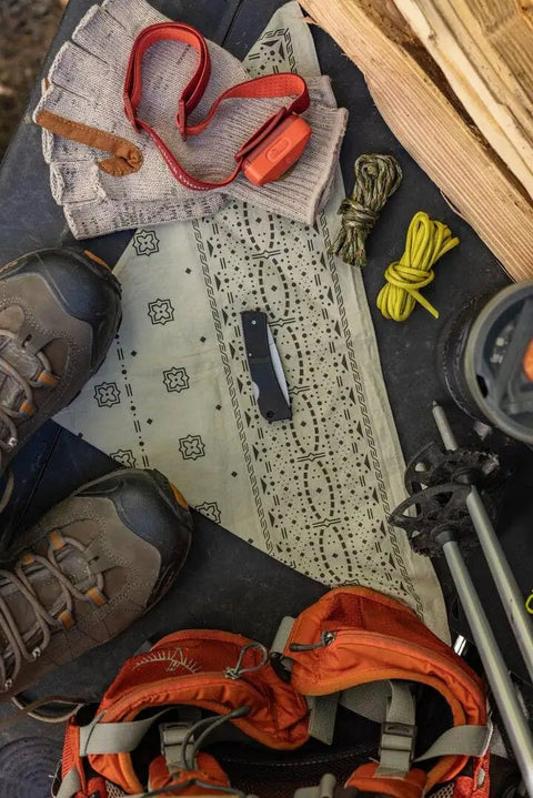 Camping scene featuring Six Point One Inch Lightweight EDC Folding Knife With Stainless Steel Blade USA Made on patterned cloth