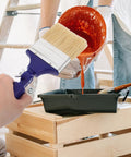 Adjustable 3 Inch Paint Brush With 270 Degree Angled Head And 2.6 Cm Aperture in use for painting with orange paint.