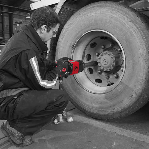 Man using Shop Beast 1 Inch Air Impact Wrench Crunching 1920 Foot Pounds Torque on truck wheel in garage.