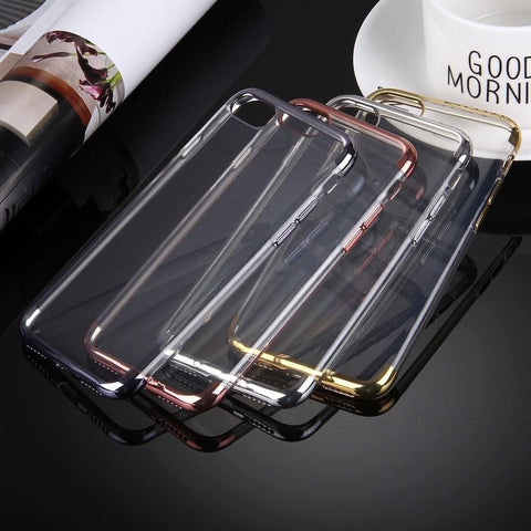 Four transparent phone cases with metallic edges in black, gold, silver, and rose gold on a reflective black surface.