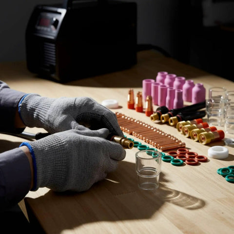 Nishiyuenyi 71 Pc Industrial Tig Consumables Kit With Torch Nozzles Cups Collets Sealing Rings on a workbench with gloves.