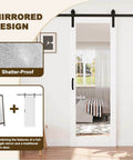 Space-Saving Barn Door With White Primed Glass Mirror Panel And Solid Wood Frame shown installed in a bedroom setting.