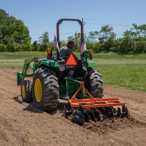 Rear view of tractor using 5ft Notched Disc Harrow Attachment For Cat 1 Tractors, 3 Point Implement With Concave Discs.
