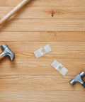 Heavy Duty Galvanized Saddle Clips For Steel Grating lying on wooden surface with hammers, showcasing durable carbon steel material.