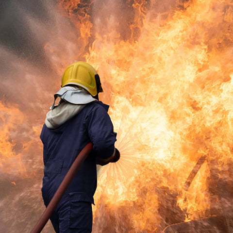 Firefighter in action wearing Lightweight Flame Resistant Coverall, 7 Oz 100 Percent Cotton FR Treated, Navy Blue, Large