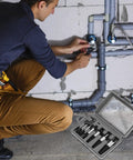 Person using the Eight Piece Water Pipe Screw Extractor Set For Damaged Screws And Bolts Alloy Steel Construction Rustproof And Heat Treated Pro Grade Plumbing Kit With Sizes One Through Eight For Quick DIY Repairs on plumbing pipes, with the extractor set visible in the foreground.