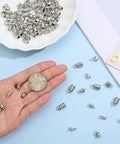 Hand holding antique silver cord end cap from 100 Pcs Cord End Caps Jewelry Making Kit With Five Styles In Antique Silver Alloy Tips Plus Lobster Clasps And Jump Rings For DIY Bracelets Necklaces And Anklets Create Custom Bling With Ease.