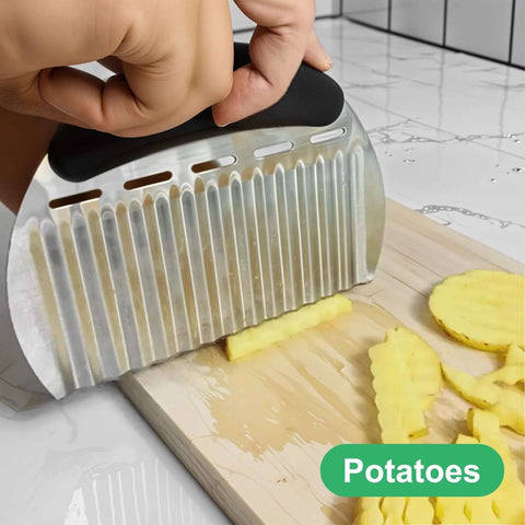 Close-up of stainless steel crinkle cutter with black handle slicing potatoes on a wooden board