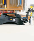 Stationary Hvlp Finishing Sprayer For Woodworkers Wanting Killer Results On Furniture Restoration Projects Using Pro Grade Metal Spray Gun next to a stainless steel container.