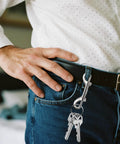 Eight Pack Heavy Duty Double Ended Snap Hooks In Silver Zinc Alloy With Trigger Clips attached to jeans belt loop holding keys.