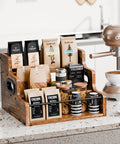 Three Tier Wooden Liquor Display Shelf For Home Bar 3 Step Countertop Rack holds coffee cups and snacks on a kitchen counter.