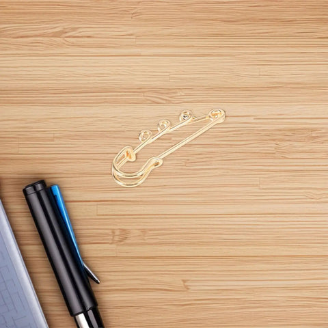 Premium 20 Pack Of Versatile Loop Safety Pin Brooches To Clasp Sweaters Scarves And Denim Belts While Adding Instant Chic Vibes To Everyday Streetwear And Casual Fits - single gold loop safety pin on wooden surface.