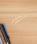 Top Shelf Loop Safety Pin Brooch Set Of Twenty Pieces Electroplated In Rich Golden Tone for secure fastening on wood surface.