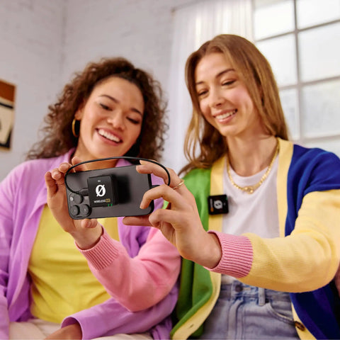 Two women using Plug-And-Play Ultra Compact Wireless Microphone System with Built-In Mics indoors for content creation.