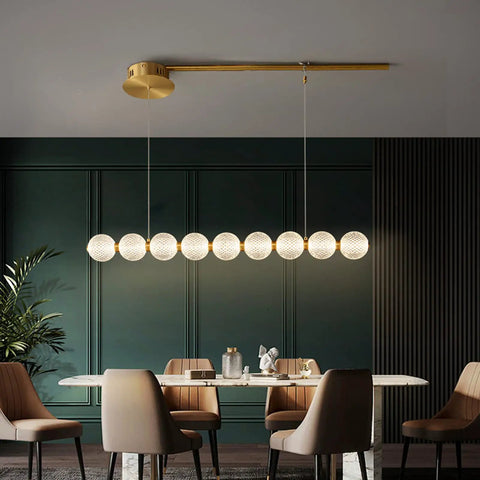 Modern Minimalist Magic Bean Chandelier With Nine Slick Brass Pendant Lights Adding Instant Vibe To Cool Cafes And Lounges While Delivering Top Notch Durability, 125cm, showcasing sleek design over a dining table.