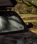 Custom Fit Rivian R2 Front Sunshade Keeps Your Whip Cool And Blocks Harsh UV Rays With Easy Fold Design And Sleek Matte Silver Finish on windshield.